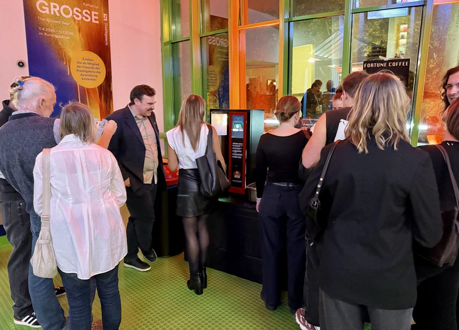 Besucher:innen drängen sich bei der Members' Night der Staatsgalerie um den Fortune-Coffee-Automaten.